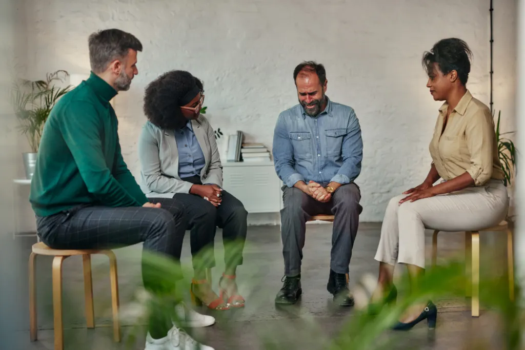 Persons from various therapy specialist collaborating in a meeting, discussing ideas and sharing expertise, representing the concept of interdisciplinary collaboration.