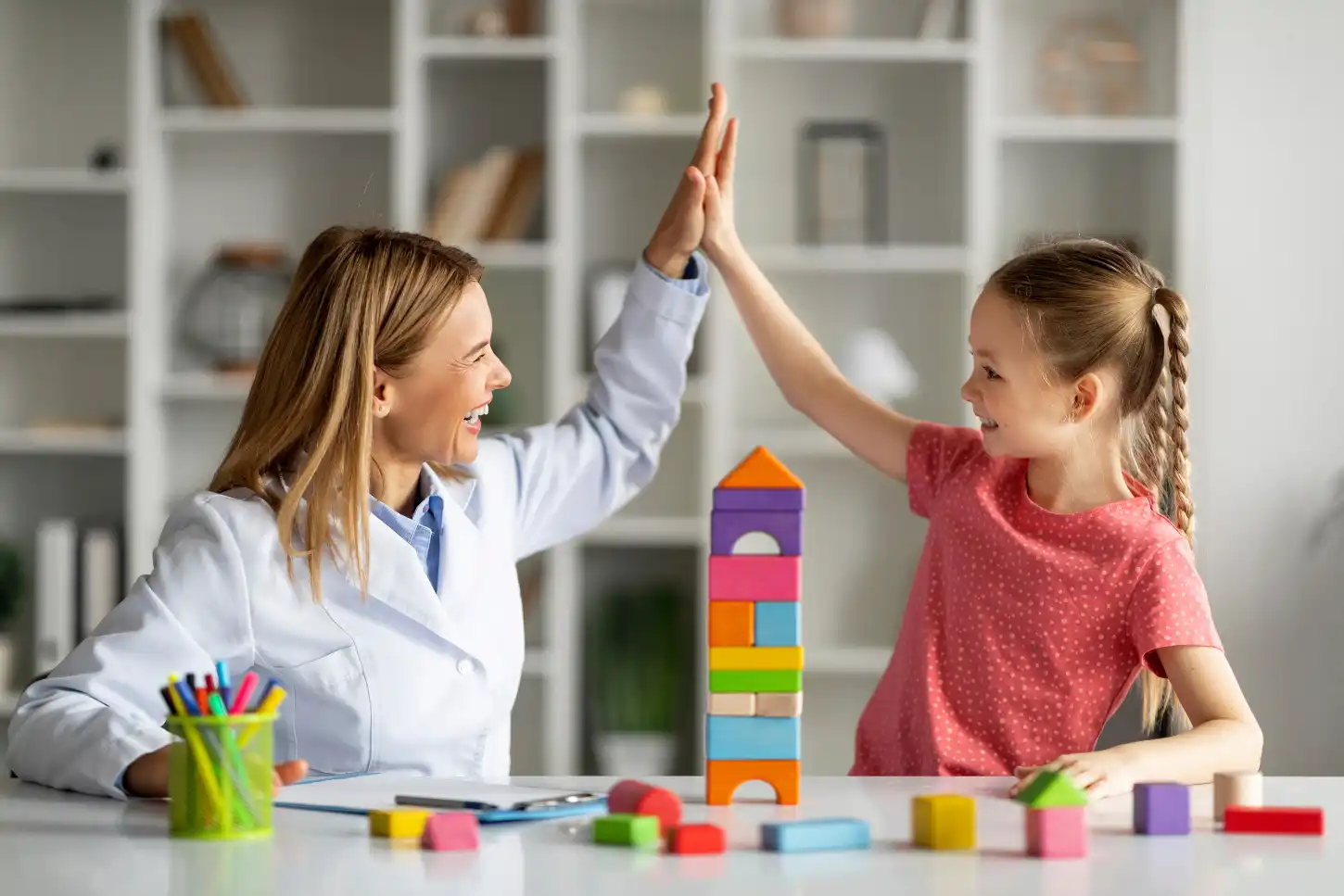 Colorful image of a pediatric therapist engaging a child in a playful therapy session, using innovative techniques and interactive materials to make therapy fun and enjoyable.