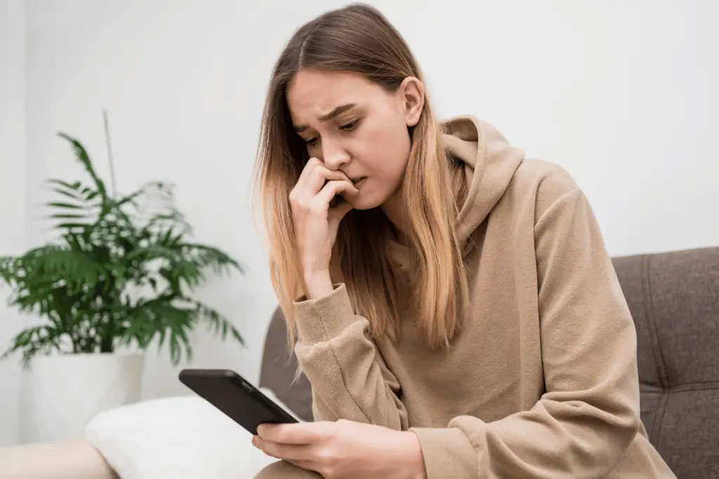 Image of a person frustrating in room with a mobile, symbolizing the concept of digital detox and the restoration of mental well-being.